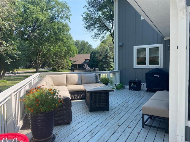 wooden deck with an outdoor hangout area and area for grilling