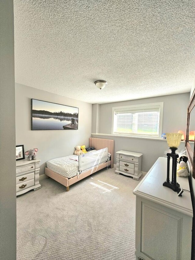 bedroom with carpet and a textured ceiling