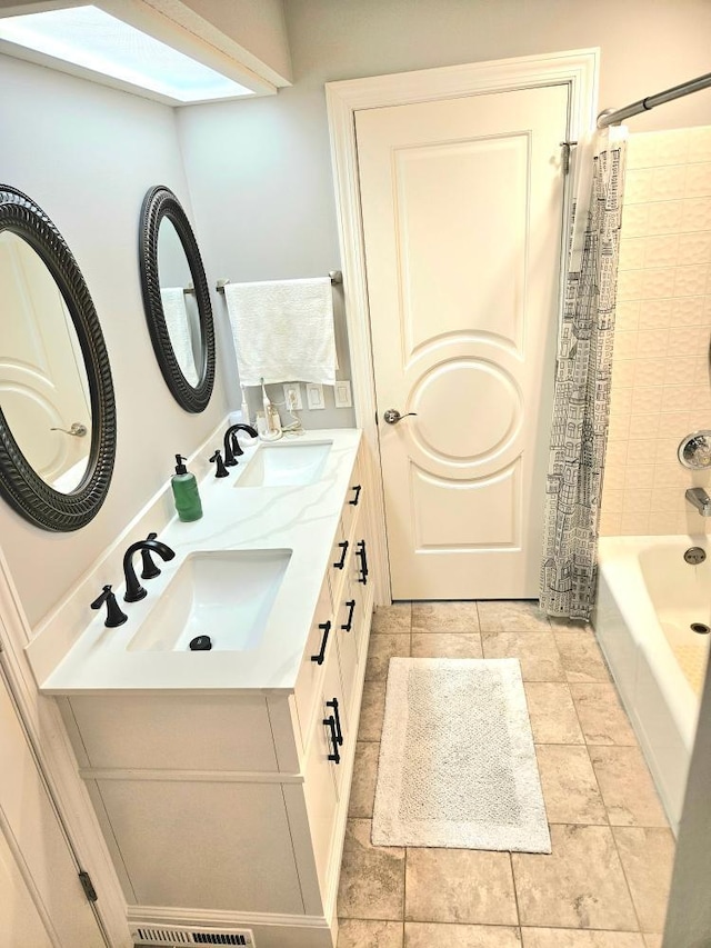 bathroom with double vanity, shower / tub combo with curtain, and a sink