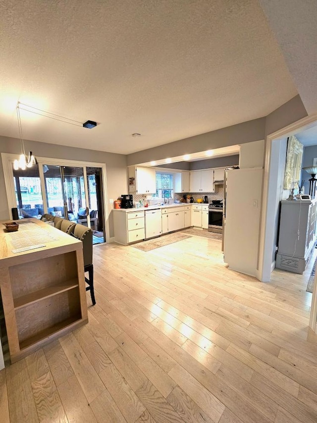 kitchen with dishwasher, stainless steel range, light wood-style flooring, and a healthy amount of sunlight