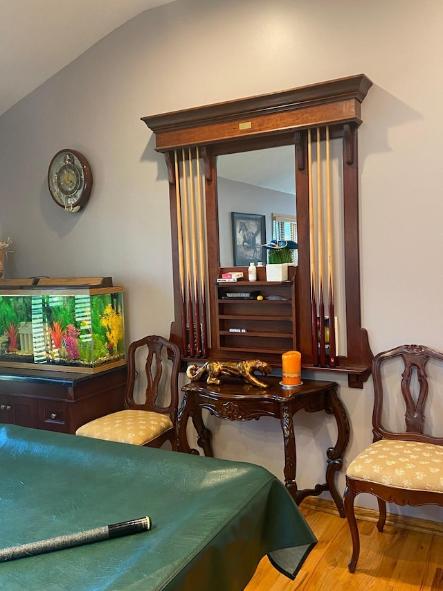 rec room with wood finished floors and vaulted ceiling