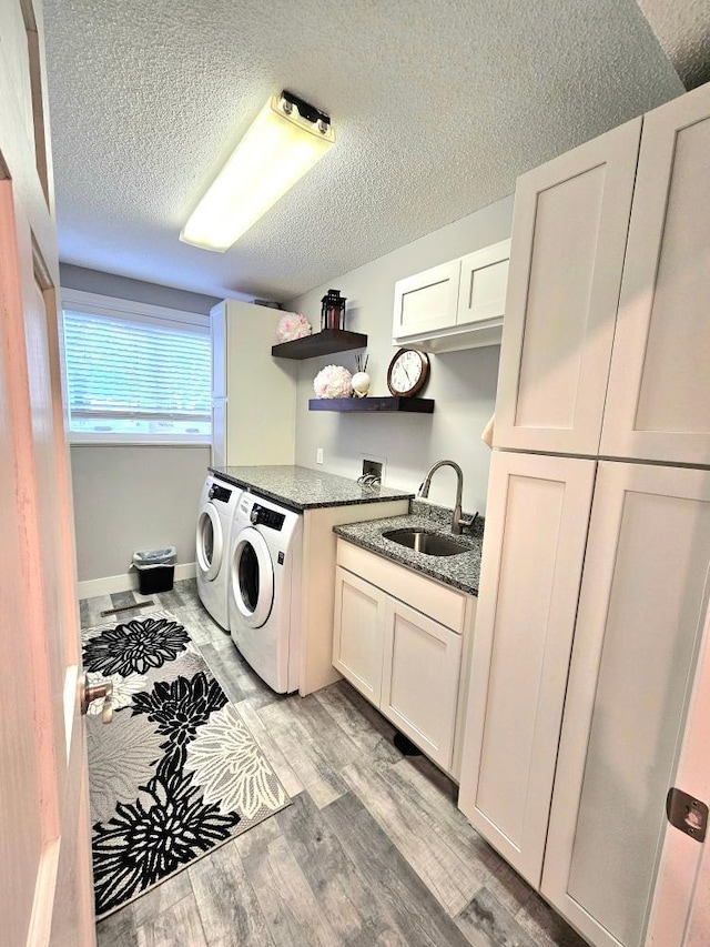 904 155th St, Burnsville, MN 55306 - washroom featuring washer and clothes dryer, cabinet space, a textured ceiling, and light wood-style floors