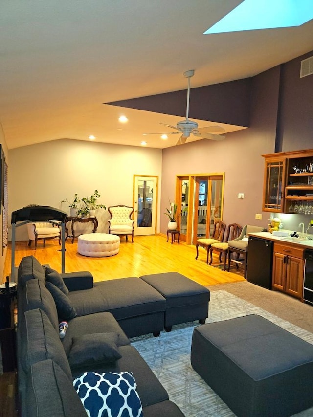 904 155th St, Burnsville, MN 55306 - living room featuring vaulted ceiling, bar with sink, light wood finished floors, ceiling fan, and recessed lighting