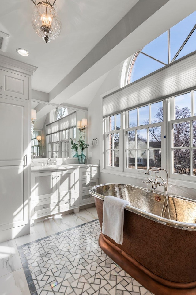 bathroom featuring double vanity, a freestanding tub, recessed lighting, vaulted ceiling, and marble finish floor