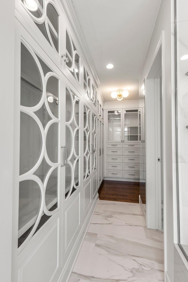 corridor with recessed lighting, marble finish floor, and ornamental molding