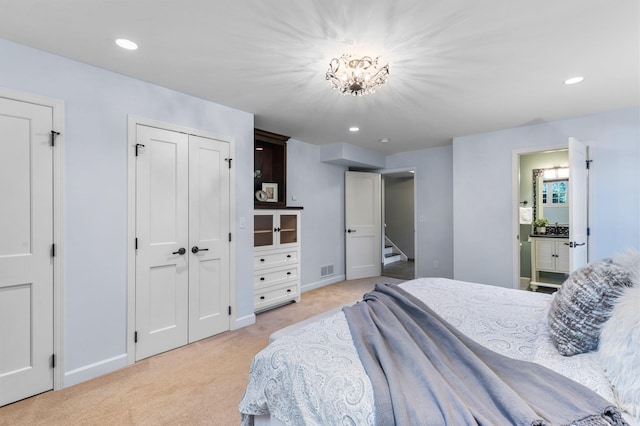 bedroom featuring recessed lighting, light colored carpet, baseboards, and connected bathroom