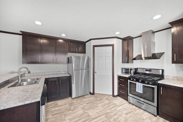 kitchen with dark brown cabinets, wall chimney range hood, light countertops, appliances with stainless steel finishes, and a sink