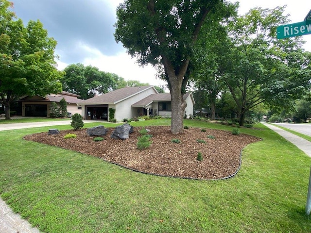 view of front of house with a garage, a front lawn, and driveway