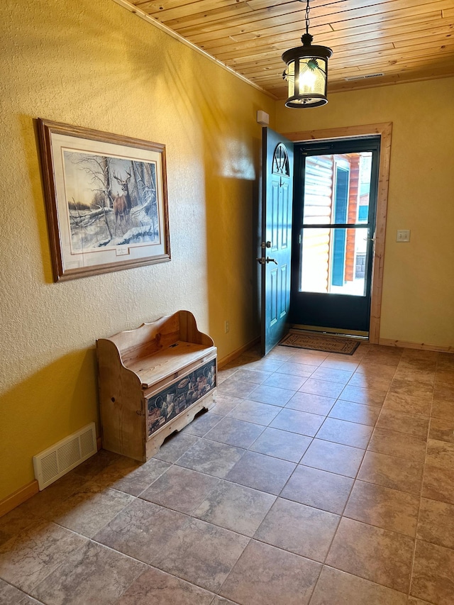 entrance foyer with wooden ceiling, baseboards, visible vents, and a textured wall