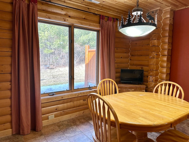 dining space featuring wood ceiling, a fireplace, and log walls