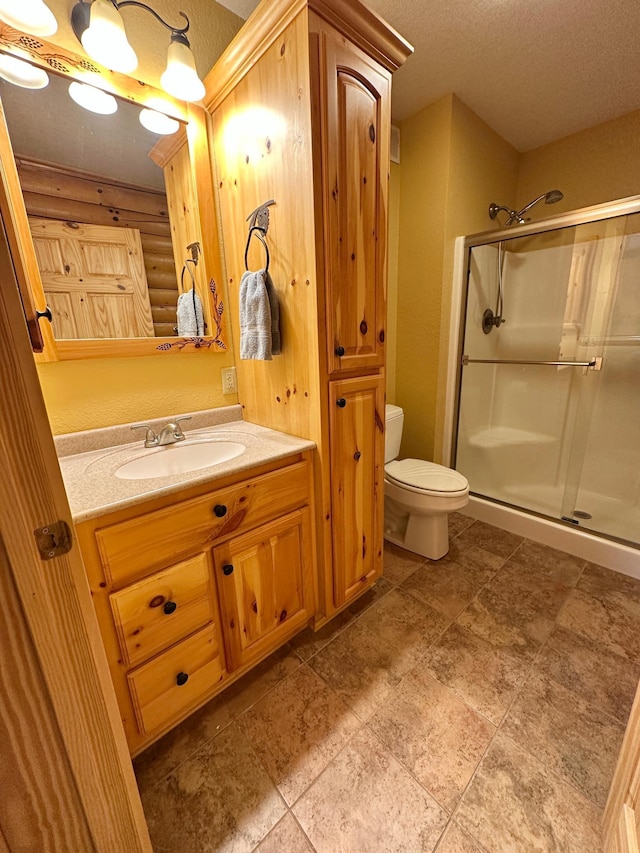 full bathroom with vanity, log walls, a stall shower, a textured ceiling, and toilet