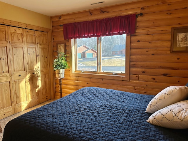 bedroom featuring rustic walls, visible vents, and carpet