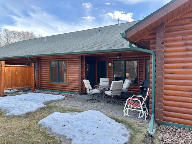 back of house featuring log siding, a patio area, fence, and a shingled roof