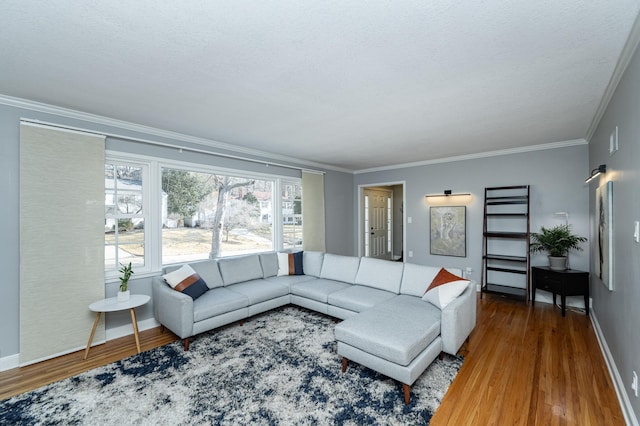 living area with crown molding, wood finished floors, baseboards, and a textured ceiling