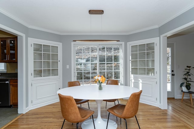 dining room with light wood-style flooring, baseboards, and ornamental molding