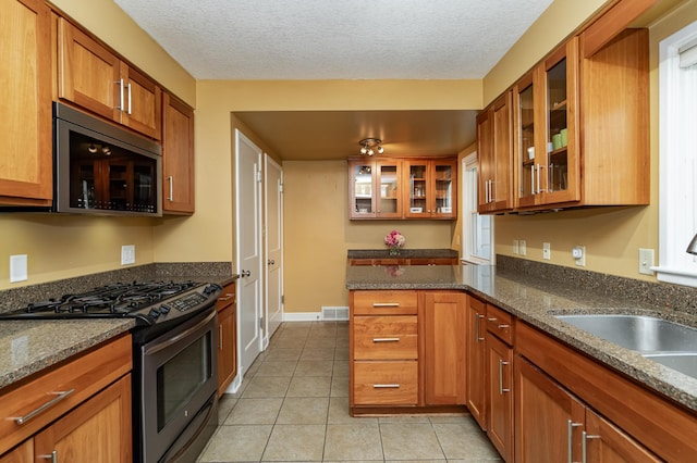 kitchen featuring a sink, stainless steel appliances, brown cabinets, and visible vents