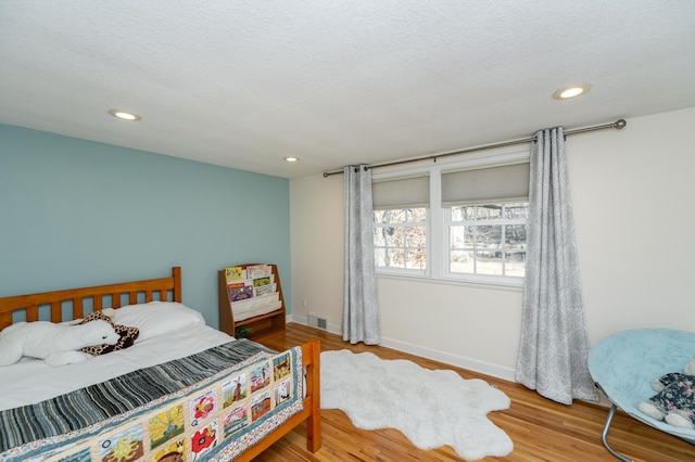 bedroom featuring recessed lighting, wood finished floors, visible vents, and baseboards