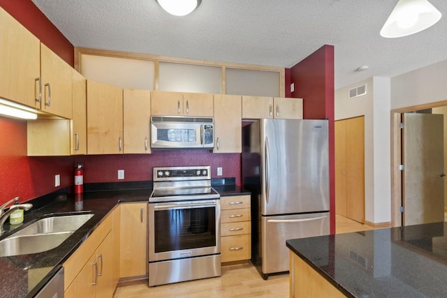 kitchen featuring a sink, stainless steel appliances, visible vents, and light brown cabinets