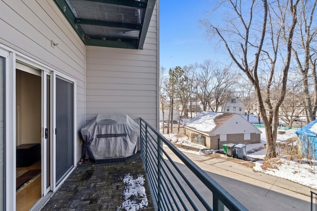 snow covered back of property with area for grilling