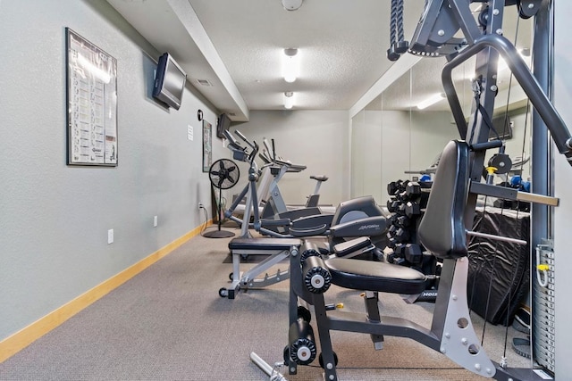 exercise room featuring visible vents, baseboards, and a textured ceiling