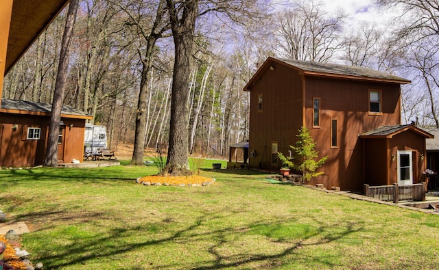 view of green lawn featuring an outbuilding
