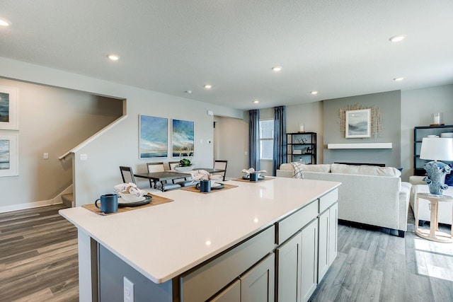 12376 81st St NE, Otsego, MN 55330 - kitchen featuring wood finished floors, a kitchen island, light countertops, recessed lighting, and open floor plan