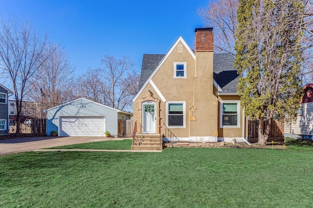 view of front of house with a detached garage, a chimney, a front yard, and fence