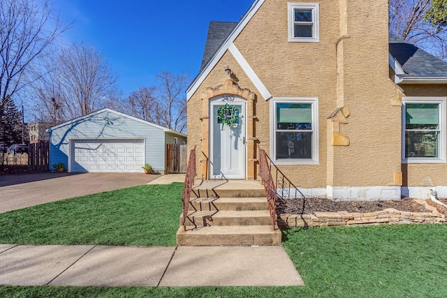 view of front of house featuring a garage, a front lawn, stucco siding, and fence