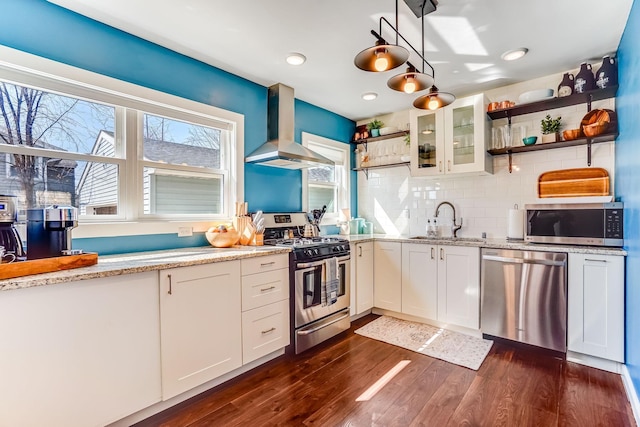 kitchen featuring range hood, open shelves, dark wood-style flooring, a sink, and stainless steel appliances