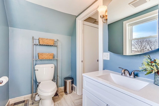 bathroom with vanity, baseboards, visible vents, vaulted ceiling, and toilet