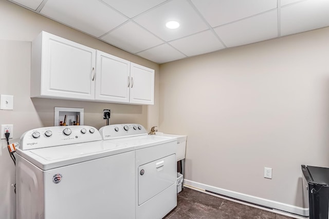 laundry area with baseboards, cabinet space, and washing machine and dryer