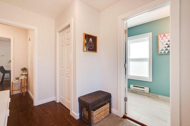 hallway with a baseboard radiator, baseboards, and dark wood finished floors