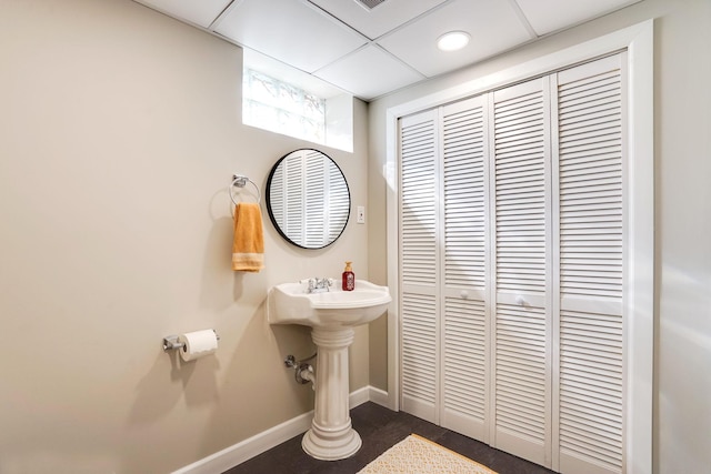 bathroom with recessed lighting, a paneled ceiling, and baseboards