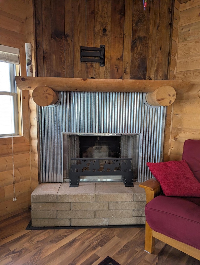 details featuring log walls, wood finished floors, and a fireplace