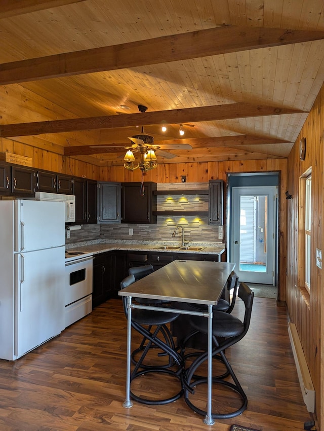 kitchen featuring white appliances, wooden walls, dark wood-style floors, a sink, and backsplash