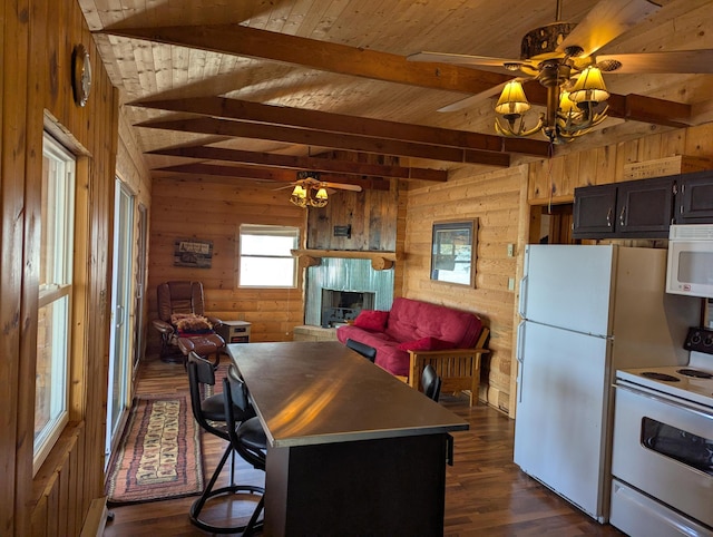 kitchen with a fireplace with raised hearth, dark wood-type flooring, wood walls, white appliances, and a ceiling fan