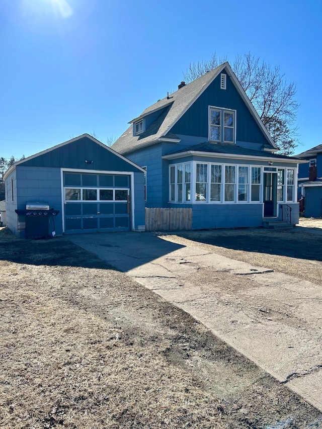 211 Hartley St, Coleraine, MN 55722 - view of front of house featuring driveway, a shingled roof, an outdoor structure, and a garage