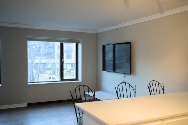 dining area with baseboards, wood finished floors, and crown molding