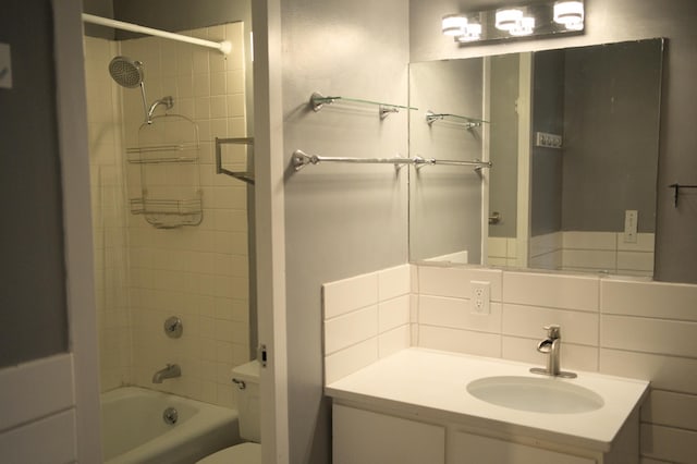 full bath featuring decorative backsplash, shower / bathing tub combination, toilet, and vanity