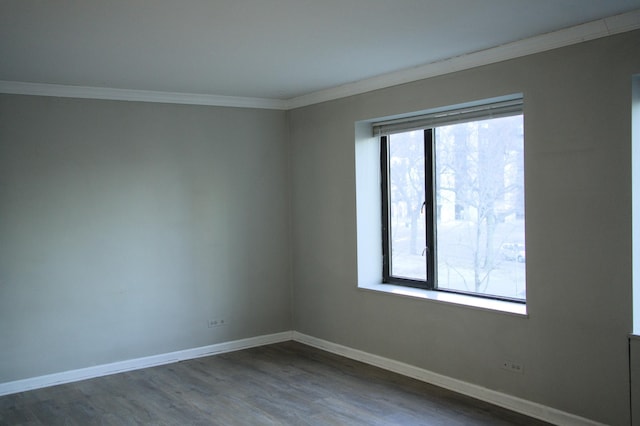 unfurnished room featuring dark wood-style floors, baseboards, and ornamental molding