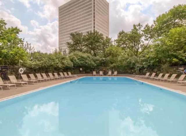 community pool featuring a patio area and fence