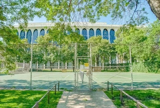 view of tennis court with a gate and fence