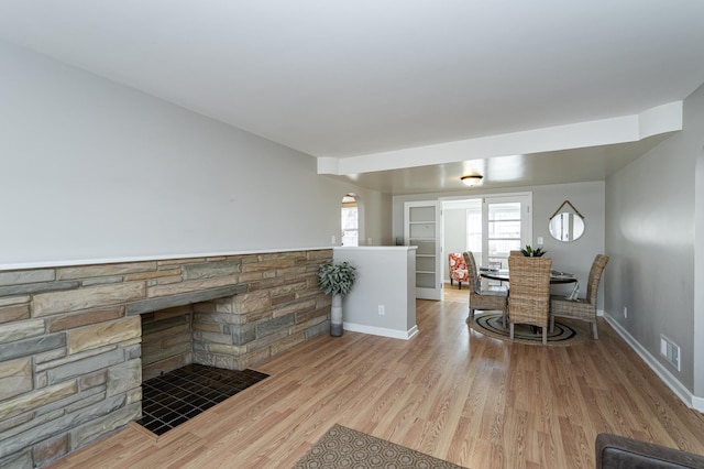 dining space with visible vents, baseboards, arched walkways, and wood finished floors