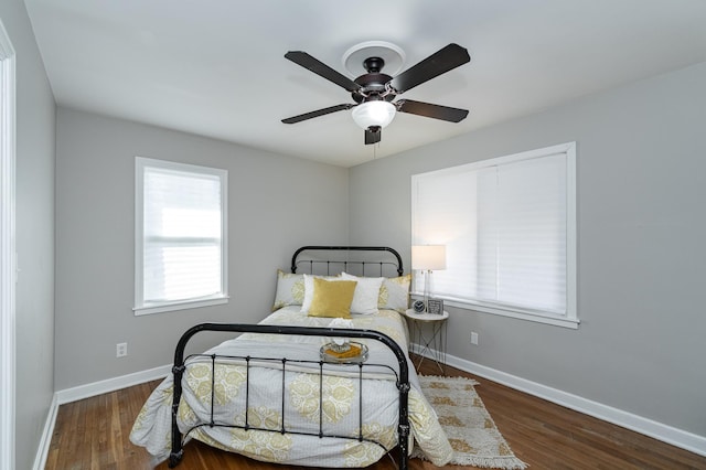 bedroom featuring wood finished floors, baseboards, and ceiling fan