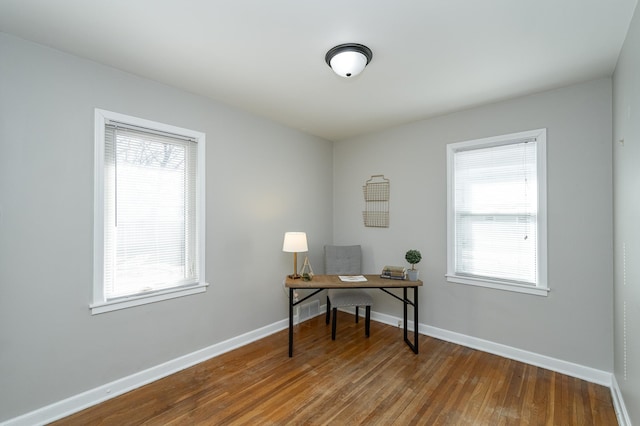 office area with plenty of natural light, baseboards, and wood finished floors