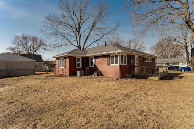 back of property with fence and central AC