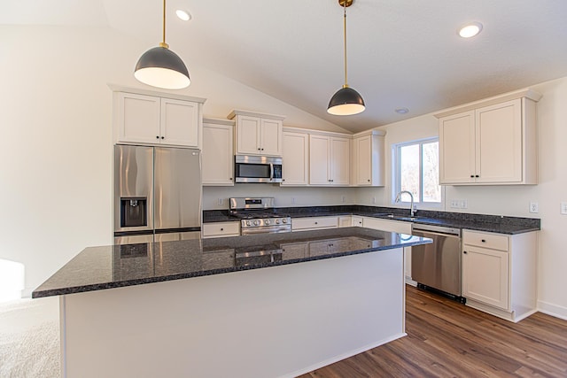 kitchen featuring a sink, a kitchen island, appliances with stainless steel finishes, and vaulted ceiling