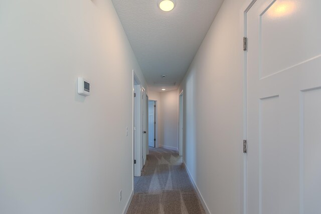 hall with recessed lighting, baseboards, a textured ceiling, and carpet flooring