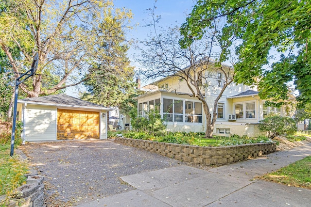 view of front of house featuring an outbuilding, a garage, and a sunroom