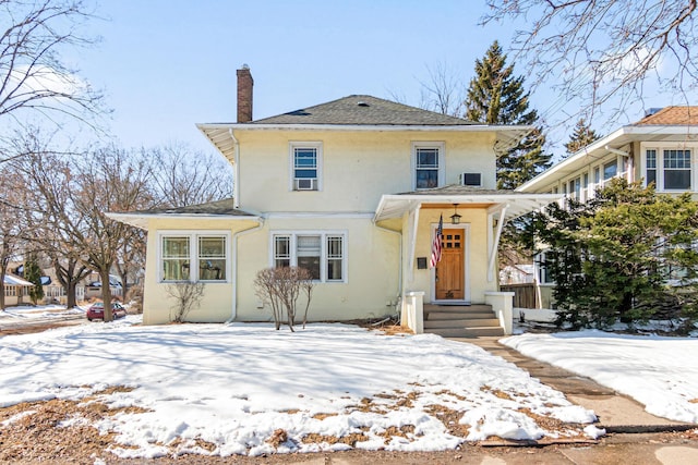 traditional style home featuring a chimney and stucco siding